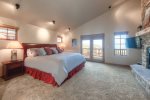 Master suite with gas fireplace, king bed, private bath, and large TV